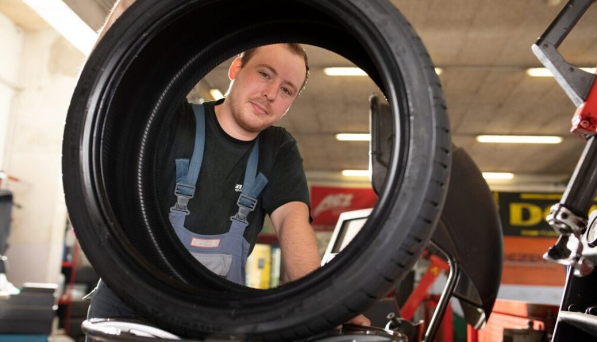 Mitarbeiter von Weichberger montiert in der Werkstätte einen Autoreifen – Reifen St. Pölten