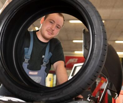 Mitarbeiter von Weichberger montiert in der Werkstätte einen Autoreifen – Reifen St. Pölten